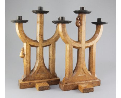 A pair of Robert 'Mouseman' Thompson oak candelabra, of gothic design with wrought iron sconces, from a set of 20 commissione