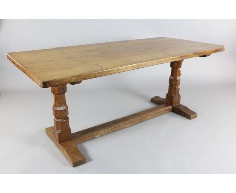 A Robert 'Mouseman' Thompson oak refectory table, with rounded rectangular top on octagonal end columns and trestle foot, one