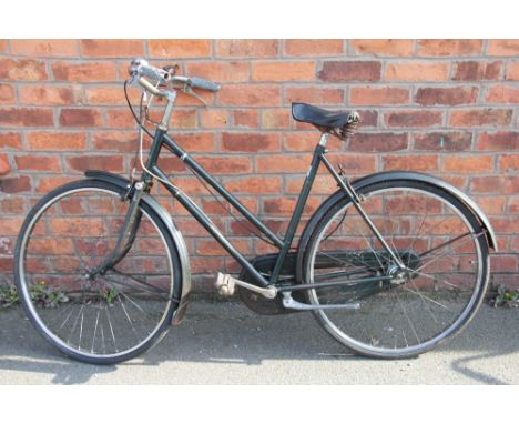 A lady's green Raleigh vintage bicycle, 3 speed with leather seat, front light and chain cover