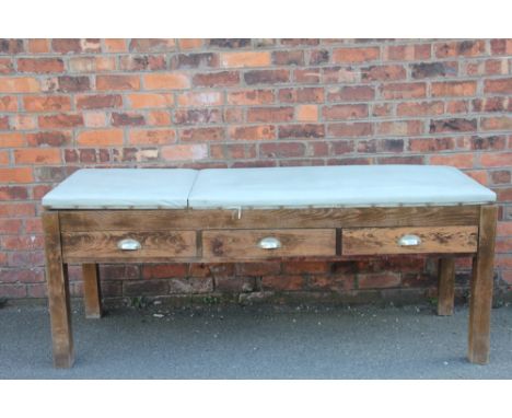 A stained pine adjustable doctors examination bed, with three drawers, on square legs, 76cm H x 182cm W x 60cm D