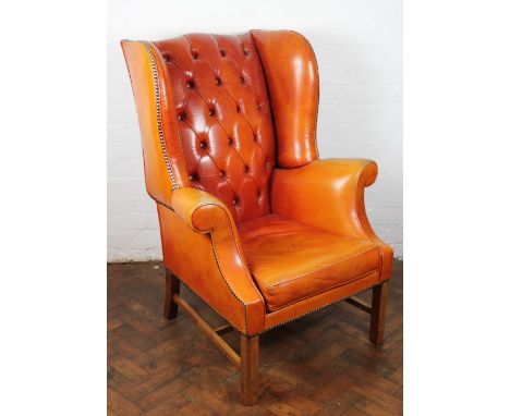 A George III style mahogany wing back arm chair, with tan leathrette button back upholstery, on moulded square legs, (a/f), 1