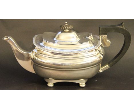 A George V silver tea pot, Sheffield, 1912, with ebonised finial and handle, on ball toes, 26.5cm long, 17toz