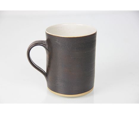Dame Lucie Rie D.B.E (1902-1995) a stoneware mug, the exterior glazed in manganese the interior white/grey glazed, LR seal ma