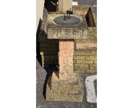 Garden sundial and pedestal simulating 'Cotswold Stone' with circular metal sundial plate over simulated brick work on steppe