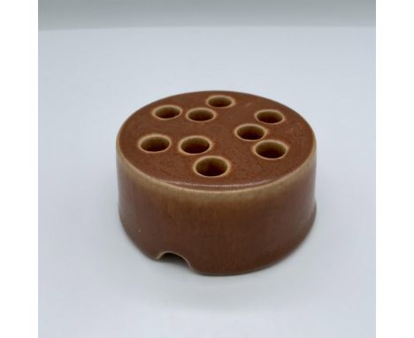Ceramic flower frog with Rookwood backstamp. Issued: Early 20th c. Dimensions: 3.25"dia. x 1.25"HManufacturer: RookwoodCountr