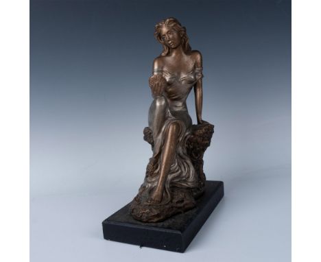 A plaster figure crafted to imitate bronze sculptures. Depicts a seated beauty admiring her reflection on a small round mirro