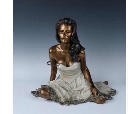 An erotic bronze statue in a golden-brass tone. Depicts a long dark-hair beauty in a white negligee. Artist, date and edition