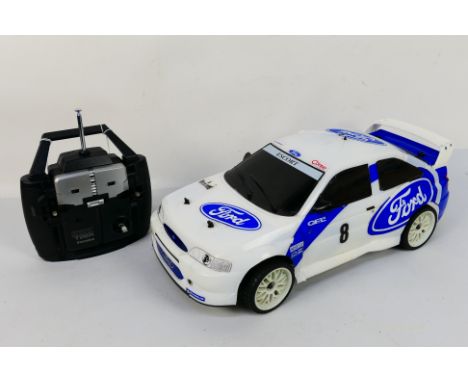 Kyosho - An unboxed Kyosho 1:10 scale nitro RC QRC Ford Escort WRC. The chassis underside has a few scratches but overall the