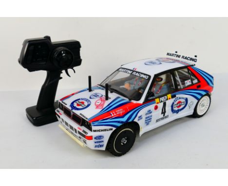 Tamiya - An unboxed Tamiya 1:10 scale electric RC Lancia Delta Integrale. The model appears to be without batteries otherwise