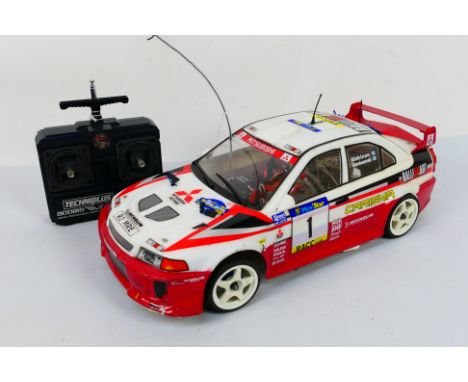 Kyosho - An unboxed Kyosho 1:8 scale nitro RC Mitsubishi Lancer Evolution VII WRC. The chassis appears Mint with hardly any s