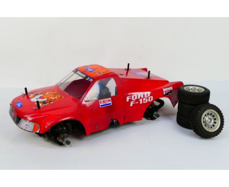 Kyosho - An unboxed and constructed Kyosho 1:10 scale nitro RC Exxon Ford F-150 Landmax 4WD . The model shows signs of use wi