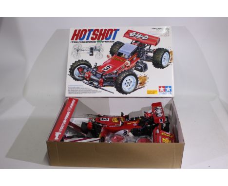 Tamiya - A boxed Tamiya 1:10 electric RC 'HotShot' High performance 4WD Off Road Racer. The model exhibits some signs of use 