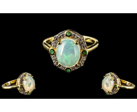 Opal and Emerald Halo Ring, a wonderfully domed cabochon cut opal of 2.25cts, giving displays of the intense internal opal co