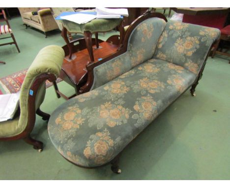 A mid Victorian walnut chaise longue with carved frame over turned and reeded legs on white ceramic castors 