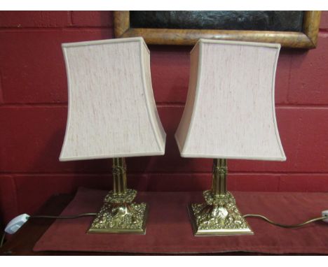 A pair of brass table lamp bases with cherubic relief 