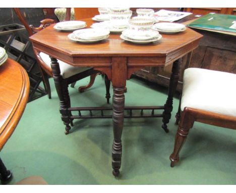 A walnut octagonal occasional table with turned cross supports and stretcher on ceramic castors, 70cm high 