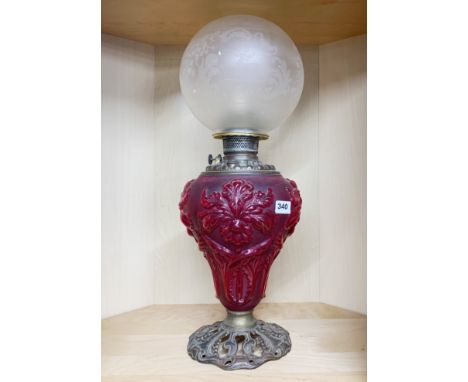 An impressive large ruby glass and gilt metal oil lamp converted for electricity with an acid etched shade, H. 60cm.