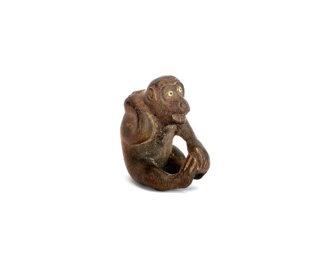 A signed fruitwood Netsuke of a monkey with inset glass eyes, H. 4.5cm.