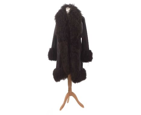 A leather and wool coat by Harrods of Knightsbridge, the smooth black leather mid length jacket with black sheepskin trim, si