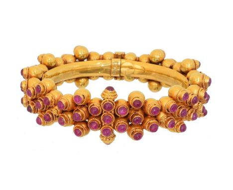 An Indian ruby hinged bangle, An Indian ruby hinged bangle, the circular ruby cabochons with wirework settings and beadwork a