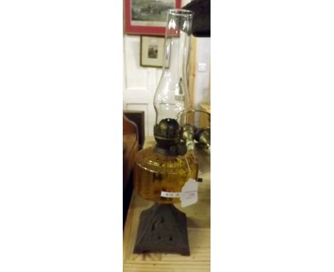 19th. C. oil lamp with cast iron base and amber glass bowl. 
