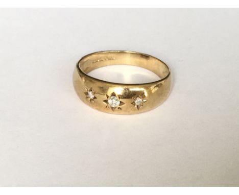 A 3 stone diamond set gypsy ring in yellow gold