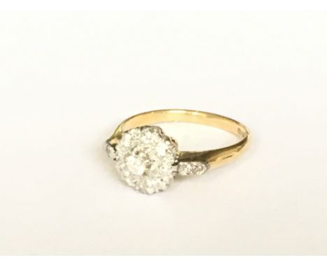 An 18ct gold cluster ring with diamond set shoulders