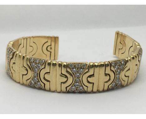 An 18carat (750) bangle each section of the bangle set with a pattern of brilliant cut round diamonds. An open slightly expan