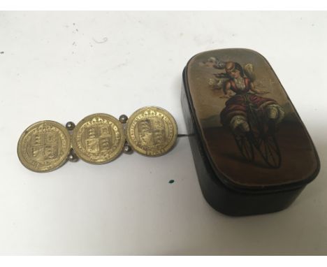 A Victorian triple coin brooch and a Victorian decorated snuff box (2)