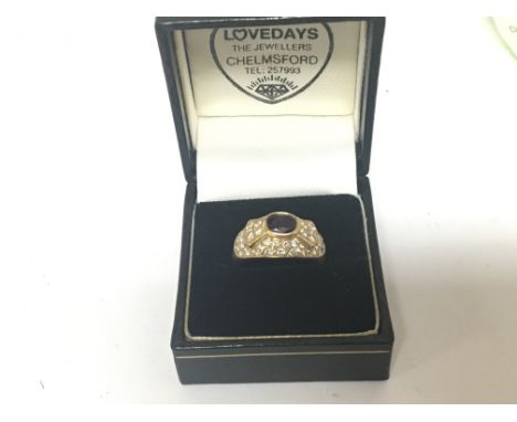 An unmarked gold ring 18carat set with a red stone and a pattern of diamonds. ring size Q-P weight 7.5g