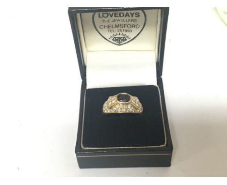 An unmarked gold ring 18carat set with a red stone and a pattern of diamonds. ring size Q-P weight 7.5g