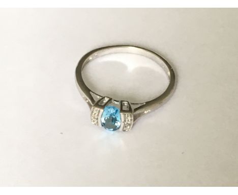 A white gold blue topaz and diamond ring