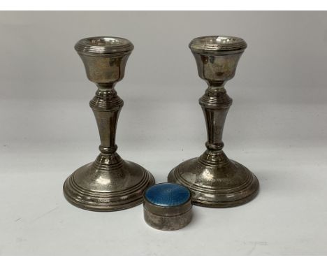 A pair of hallmarked silver candlesticks together with a small guilloche enamel pill box.