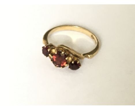 A 3 stone crossover garnet set ring in 9ct gold