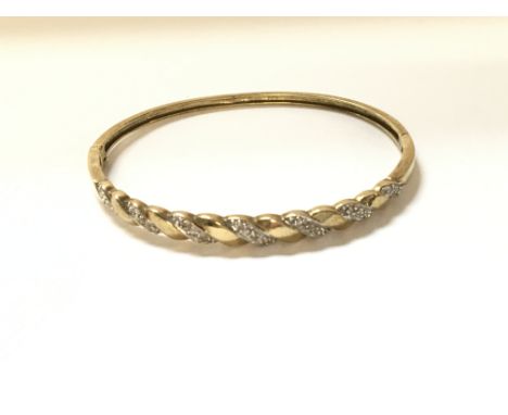 A 9ct gold bangle with diamonds. Weight 8.7g
