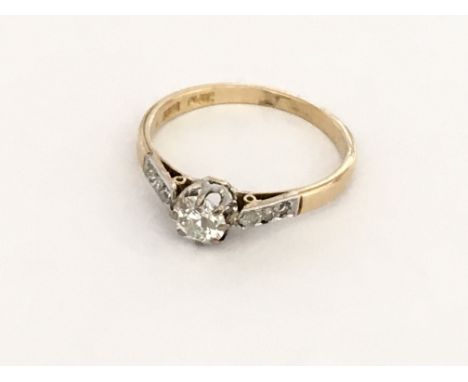 An 18ct gold and platinum diamond ring with diamond set shoulders