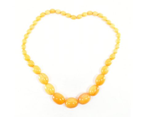 A vintage yellow amber bakelite beaded necklace. The necklace comprised of graduated olive shaped amber plastic bakelite bead