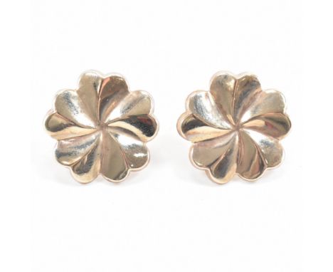 A pair of vintage yellow gold stud earrings. The earrings both in repousse to depict a cherry blossom flower to straight post