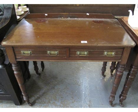 Edwardian mahogany side table, having moulded top above two pull out drawers on ring turned supports and casters. (B.P. 21% +