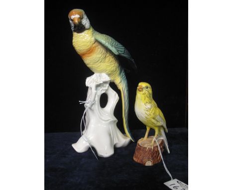 Continental porcelain study of a long tailed parrot on a tree stump, together with a Goebel figure of another bird. (2)(B.P. 