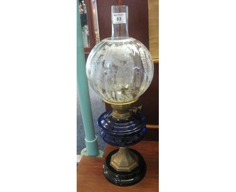 Early 20th Century brass double burner oil lamp with blue glass reservoir on metal pedestal with ceramic foot, with etched gl