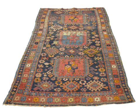 A Caucasian Sumakh style rug
With three central canted square design medallions before a dark blue ground with geometric desi