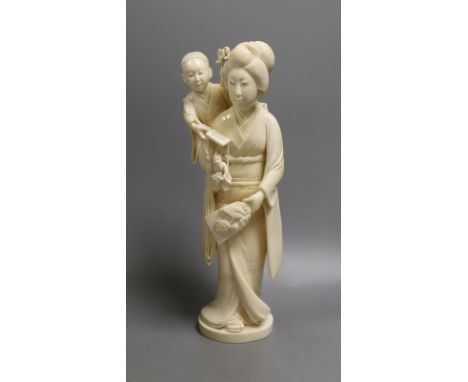 A large Japanese Tokyo School ivory okimono of a lady with child holding a puppet, Meiji period, 31 cms high.