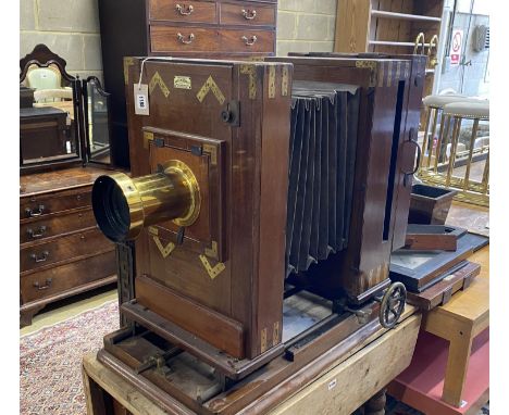 An early 20th century Hunter-Penrose Ltd. brass mounted mahogany studio plate camera, with 4in. lens, height 78cm, width 49cm