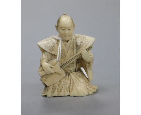 A Japanese netsuke of a figure playing biwa height 7cm