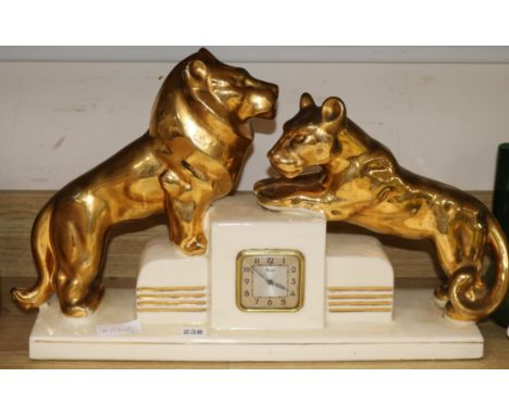 A Rozay ceramic Art Deco clock mounted with lion cubs length 58cm
