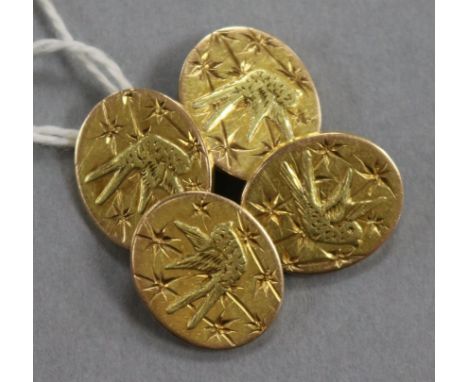 A pair of yellow metal cufflinks engraved with aesthetic birds.