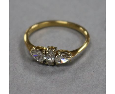 An 18ct gold and three stone diamond ring, set with pear and marquise cut stones, size K.