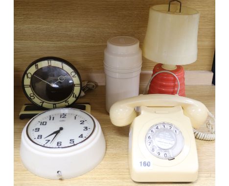 A cream bakelite telephone, a bakelite lamp, a thermos flask and two clocks