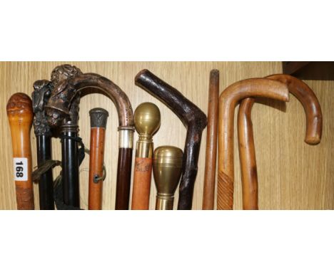 A white metal mounted walking stick and collection of other sticks